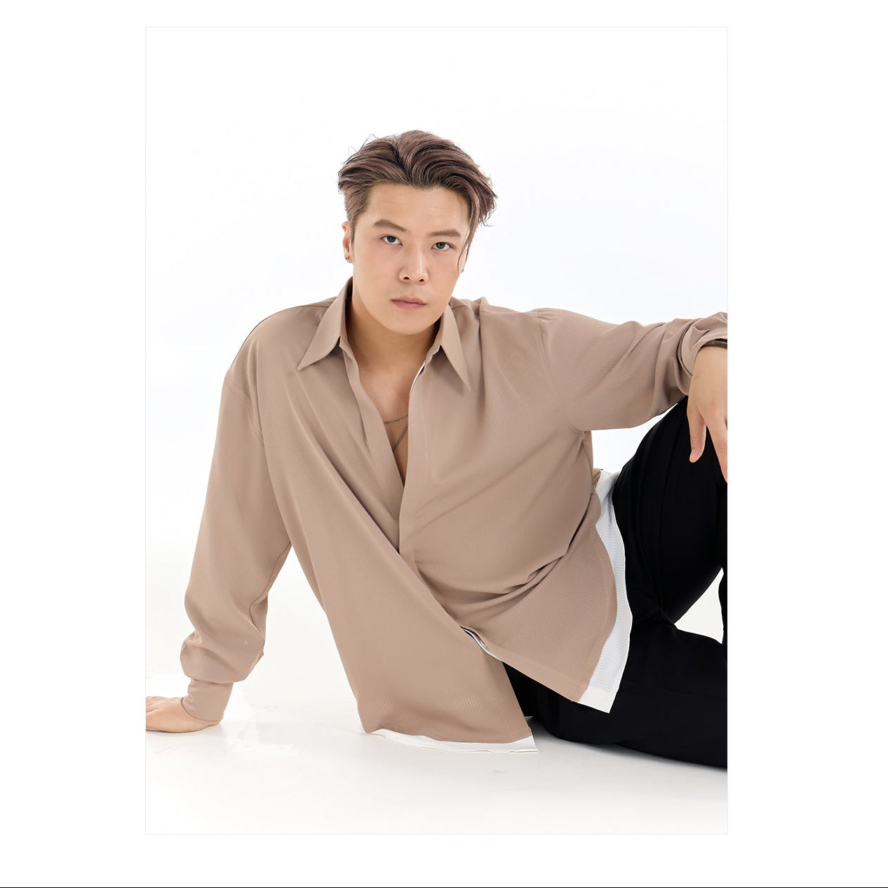 Man wearing a beige shirt and black pants on a white background with 'DUYQ DESIGN' branding.