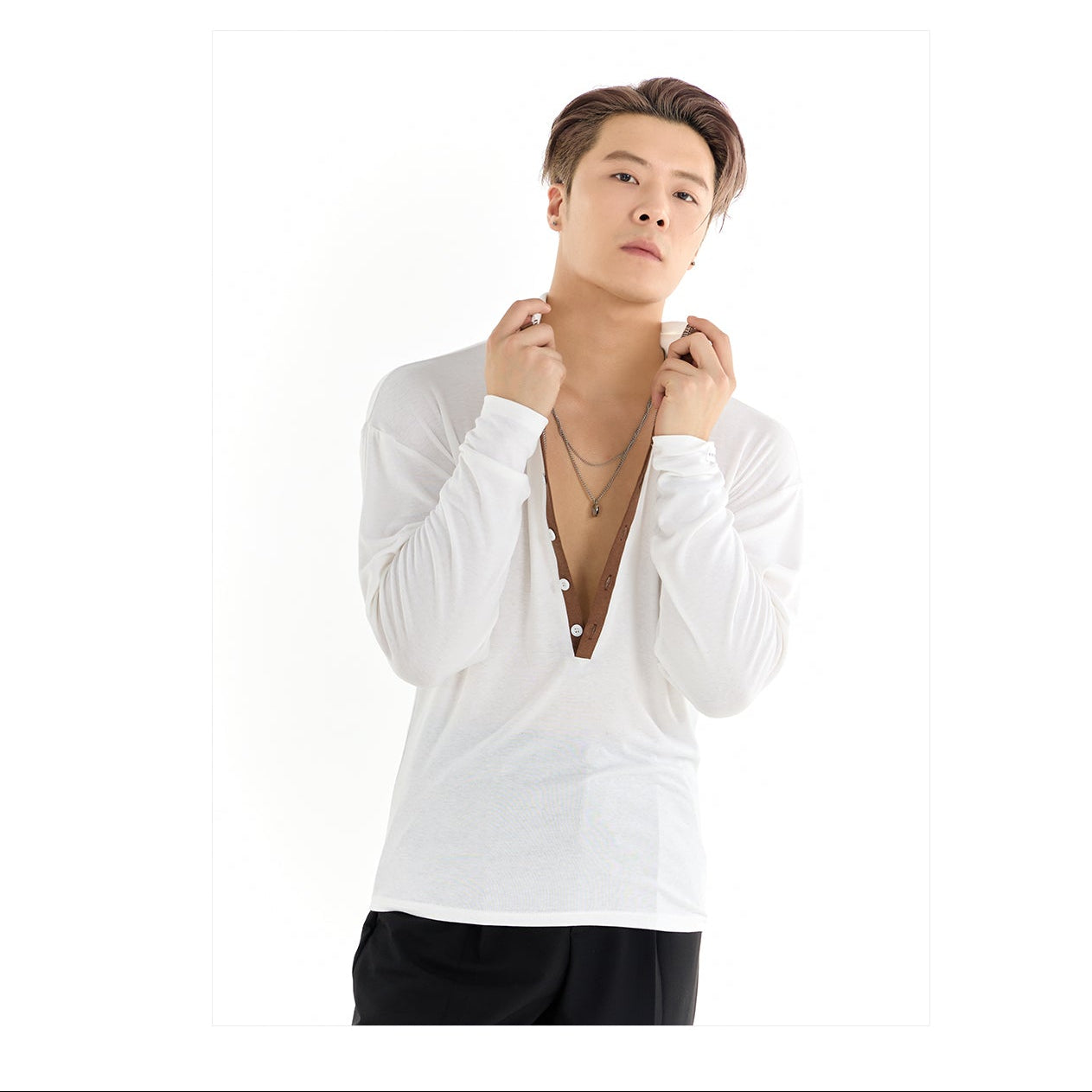 Person wearing a white shirt with a brand logo in the corner