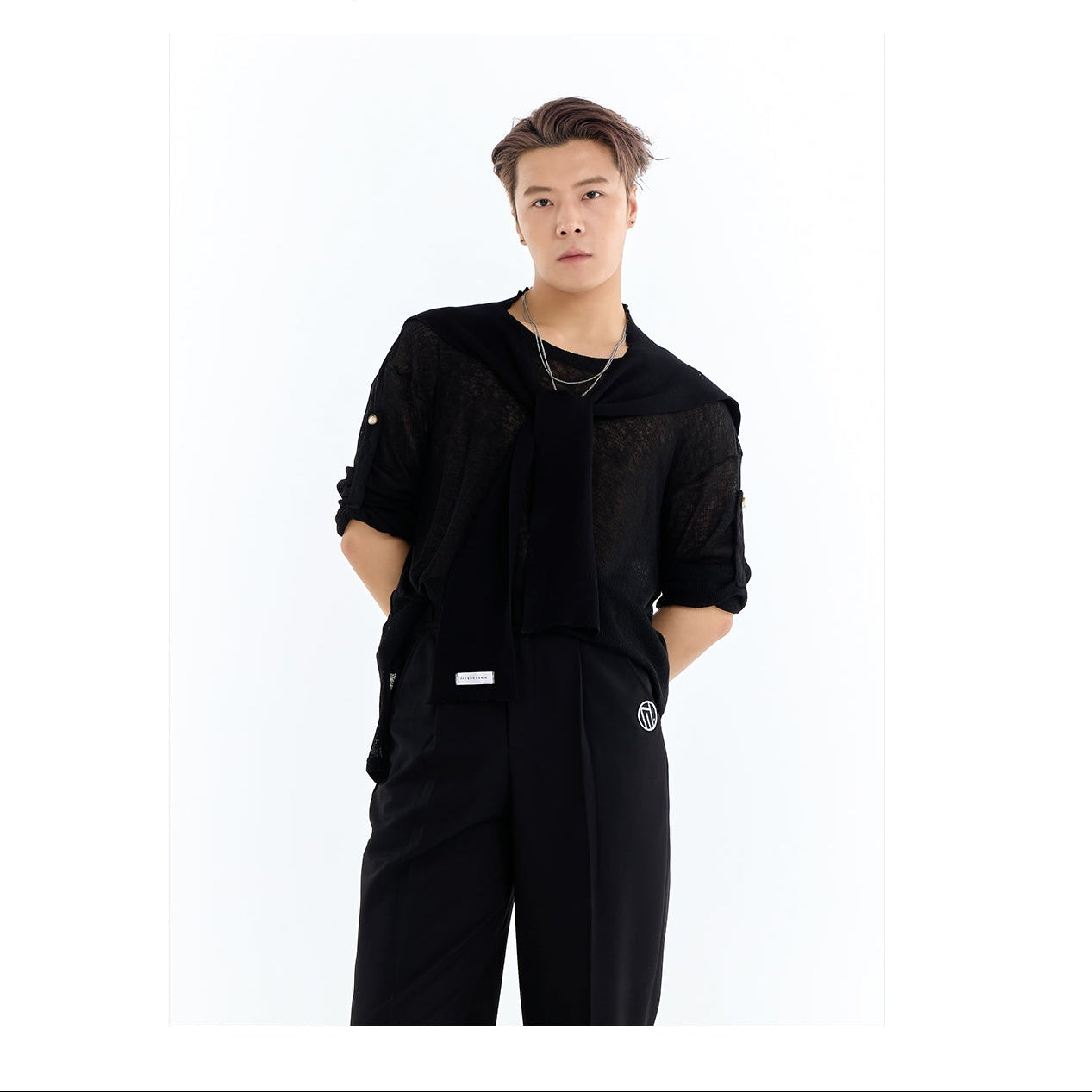 Person wearing a black outfit with 'DUYQ DESIGN' logo on a white background