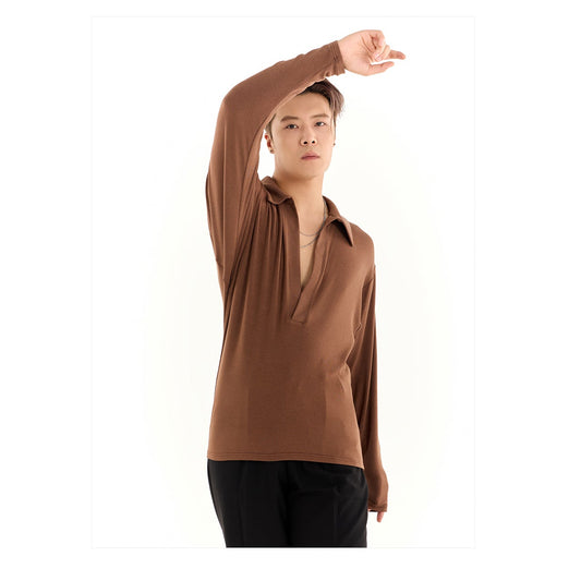 Person wearing a brown long-sleeve shirt with a brand logo above