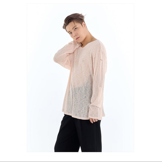 Person wearing a light pink shirt with a brand logo in the corner