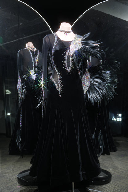 Black evening gown with intricate detailing on a mannequin in a darkly lit room.