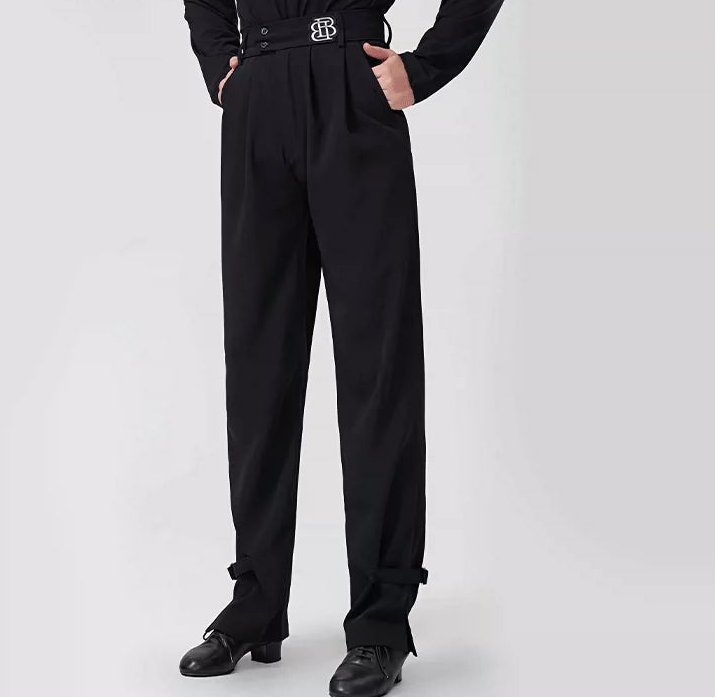 A model wearing black BOBO DANCE high-waisted dance pants with a matching black belt featuring a silver 'BD' logo, paired with a black long-sleeve top and black dance shoes, against a light gray background.