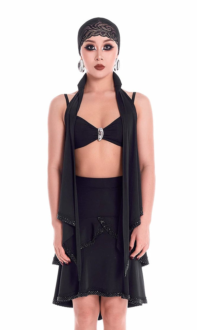 Model wearing a black outfit with a headscarf on a white background