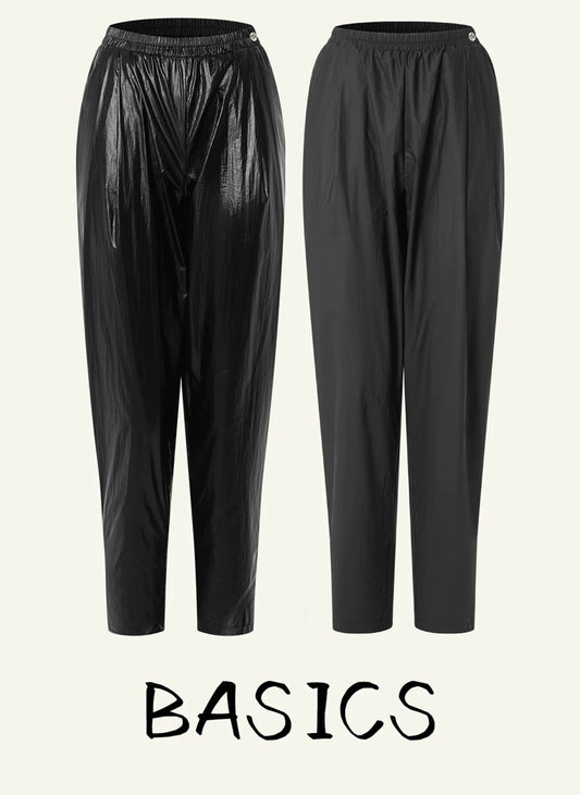 Two pairs of black basic pants shown side by side on a light beige background, with the text 'BASICS' below. One pair has a glossy finish and the other is matte, both with elastic waistbands.